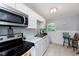 Bright kitchen with modern stainless steel appliances, white cabinetry, and a window above the sink at 3338 Orchard Ave, Indianapolis, IN 46218