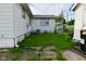 Side yard featuring a detached garage, lush green lawn, and tidy landscaping at 341 Barton Ave, Indianapolis, IN 46241