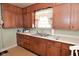 The kitchen has wood cabinets, a double stainless sink, and vintage details at 341 Barton Ave, Indianapolis, IN 46241