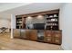 Basement bar area with custom wood cabinets, beverage refrigerators, and decorative shelving at 3713 Cherwell Dr, Zionsville, IN 46077
