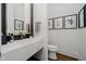 Modern powder room featuring a floating marble vanity, gold faucet, and botanical prints at 3713 Cherwell Dr, Zionsville, IN 46077