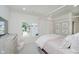 Serene bedroom with a four-poster bed, soft pink accents, and a large window overlooking the outdoors at 3713 Cherwell Dr, Zionsville, IN 46077