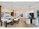 A modern kitchen and dining area are showcased with an island, pendant lights and round dining table at 3713 Cherwell Dr, Zionsville, IN 46077
