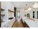 A chef's kitchen offers white cabinetry, a center island and a view of the home's entry at 3713 Cherwell Dr, Zionsville, IN 46077