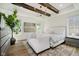 Bright main bedroom features wood beams, hardwood floors, and sitting area with a sofa at 3713 Cherwell Dr, Zionsville, IN 46077