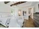 Bright main bedroom features wood beams, hardwood floors, and sitting area with a sofa at 3713 Cherwell Dr, Zionsville, IN 46077