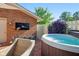 Outdoor hot tub with seating, set amongst brick pavers, lush landscaping, and a privacy fence at 3975 Offshore Dr, Columbus, IN 47203