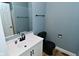Modern bathroom with black faucet, white vanity, large mirror and black toilet at 4029 Gamay Ln, Indianapolis, IN 46254