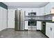 Well-lit kitchen featuring stainless steel appliances, white cabinets, and dark countertops at 4029 Gamay Ln, Indianapolis, IN 46254
