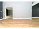 Spacious living room with light wood floors and neutral gray walls, door leading to second room at 4029 Gamay Ln, Indianapolis, IN 46254
