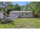 Backyard with a small deck area, a stone fire pit, a grassy yard, and mature trees at 420 Vista Dr, Carmel, IN 46280