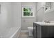 Bathroom featuring subway tile, a window, and a gray vanity with a sink and silver faucet at 420 Vista Dr, Carmel, IN 46280