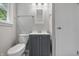 Bright bathroom featuring a gray vanity and sink, a window and a toilet at 420 Vista Dr, Carmel, IN 46280