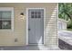 Close-up of the front door, highlighting its glass-paneled design and classic style, complemented by neutral siding and an outdoor light at 420 Vista Dr, Carmel, IN 46280