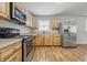 Well lit kitchen featuring stainless steel appliances, light wood cabinetry, and wood look flooring at 420 Vista Dr, Carmel, IN 46280