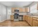 Well-lit kitchen showcasing stainless steel appliances, light wood cabinets, and hardwood floors, creating a functional and stylish space at 420 Vista Dr, Carmel, IN 46280
