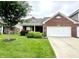 Charming single-story brick home featuring an attached garage and well-maintained landscaping at 4209 Switchgrass Way, Indianapolis, IN 46237