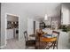 Dining area adjacent to the kitchen features a glass-top table, modern lighting, and easy access to the laundry room at 4736 Rocky Knob Ln, Indianapolis, IN 46254