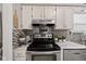 Close up of kitchen range with white cabinets, mosaic tile backsplash, and stainless steel appliances at 4736 Rocky Knob Ln, Indianapolis, IN 46254