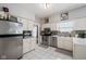 Bright kitchen with stainless steel appliances, white cabinets, mosaic backsplash, and white tile flooring at 4736 Rocky Knob Ln, Indianapolis, IN 46254