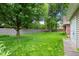 Large, grassy backyard featuring a privacy fence, mature trees, and views of the house at 4904 N Tillotson Ave, Muncie, IN 47304