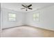 Bright bedroom with neutral carpet, white walls, ceiling fan, and large windows allowing ample natural light at 4904 N Tillotson Ave, Muncie, IN 47304