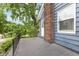 Charming balcony featuring a brick chimney, blue siding, and black railing, offering outdoor space at 519 Woodruff Place Middle Dr, Indianapolis, IN 46201