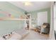 Cozy bedroom with a tent-style bed, rocking chair, and light green walls at 519 Woodruff Place Middle Dr, Indianapolis, IN 46201