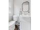 Powder room featuring modern fixtures, a stylish mirror, and natural light at 519 Woodruff Place Middle Dr, Indianapolis, IN 46201
