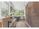 Bright sunroom with a brick wall, lots of windows, and space for both a table and play area at 519 Woodruff Place Middle Dr, Indianapolis, IN 46201