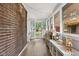 Charming sunroom with exposed brick, large windows, and ample natural light at 519 Woodruff Place Middle Dr, Indianapolis, IN 46201