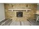 The stone fireplace with a white mantel and decorative sconces accents this living space with modern flooring at 5331 Birch Ln, Greenwood, IN 46143