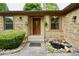 Stone house exterior showcasing front door, lantern fixtures, hanging plants, and a small fish pond in the landscape at 5331 Birch Ln, Greenwood, IN 46143