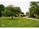 Traditional ranch home with a stone exterior, manicured lawn, mature trees, and long driveway, offering curb appeal at 5331 Birch Ln, Greenwood, IN 46143