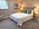 Cozy bedroom featuring neutral walls, plush carpeting, and a comfortable queen-sized bed with decorative pillows at 5348 Crittenden Ave, Indianapolis, IN 46220