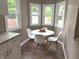 Charming breakfast nook featuring white chairs, round table, and bright natural light from multiple windows at 5348 Crittenden Ave, Indianapolis, IN 46220