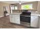 Open-concept kitchen with granite counters, stainless steel oven, white cabinets, and modern lighting at 5348 Crittenden Ave, Indianapolis, IN 46220