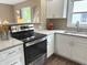 Well-lit kitchen with granite countertops, stainless steel oven, white cabinets, and stainless steel appliances at 5348 Crittenden Ave, Indianapolis, IN 46220
