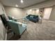 Bright finished basement living room with a modern gray couch, teal chairs and contemporary art at 5348 Crittenden Ave, Indianapolis, IN 46220
