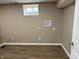 Empty room with wood-look flooring, outlets, and window, ready for washer and dryer hookups at 5348 Crittenden Ave, Indianapolis, IN 46220