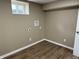 Empty room with wood-look flooring, outlets, and window, ready for washer and dryer hookups at 5348 Crittenden Ave, Indianapolis, IN 46220