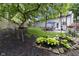 Spacious backyard with mature trees, manicured lawn, landscaped garden, and a patio with outdoor seating area at 5543 N Pennsylvania N St, Indianapolis, IN 46220