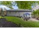 Well-manicured backyard featuring lush green grass, mulched garden beds, and a patio with outdoor dining set at 5543 N Pennsylvania N St, Indianapolis, IN 46220
