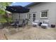 Concrete backyard patio with outdoor seating shaded by a large blue umbrella; great for entertaining at 5543 N Pennsylvania N St, Indianapolis, IN 46220