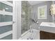 This bathroom boasts a glass shower with decorative tile and a modern sink with wooden cabinets at 5543 N Pennsylvania N St, Indianapolis, IN 46220