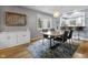 Dining room featuring modern chandelier, hardwood floors, and open access to the adjacent kitchen with bar seating at 5543 N Pennsylvania N St, Indianapolis, IN 46220