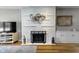 Modern fireplace with white brick and display shelving with hardwood flooring and stainless steel fire screen at 5543 N Pennsylvania N St, Indianapolis, IN 46220