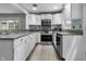 Well-lit kitchen featuring white cabinets, tile backsplash, and stainless steel appliances at 5543 N Pennsylvania N St, Indianapolis, IN 46220