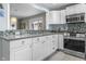 Kitchen with white cabinets, stainless steel appliances, and view of dining area at 5543 N Pennsylvania N St, Indianapolis, IN 46220