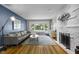 Bright living room with large window, brick fireplace, hardwood floors, and comfortable seating area at 5543 N Pennsylvania N St, Indianapolis, IN 46220